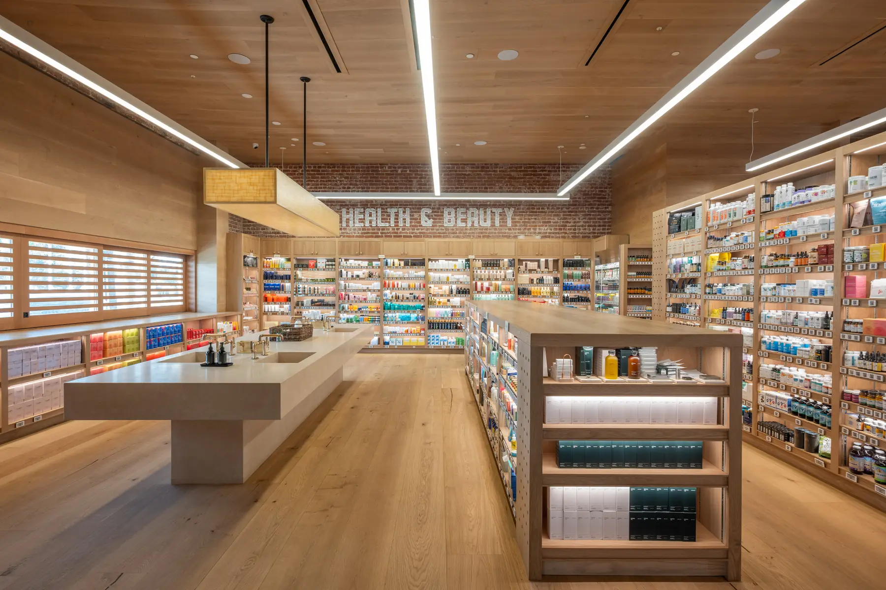 Wood shelving of health and beauty products around a stone counter